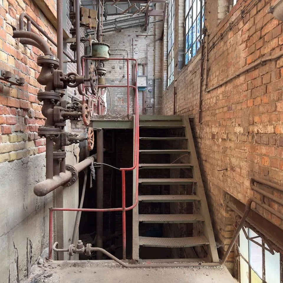 Industrial machinery and heavy piping inside the abandoned steam power station in Forst-Lausitz