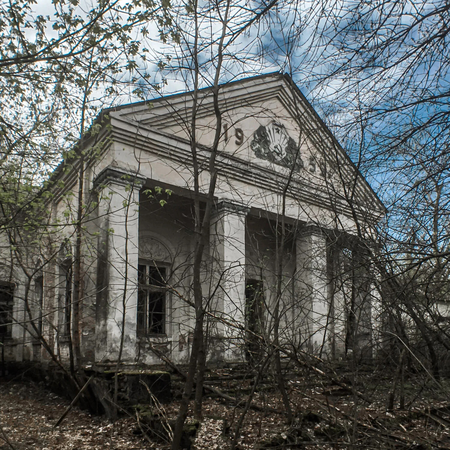 The overgrown entrance and colonnade of the abandoned Palace of Culture in Zalyssia