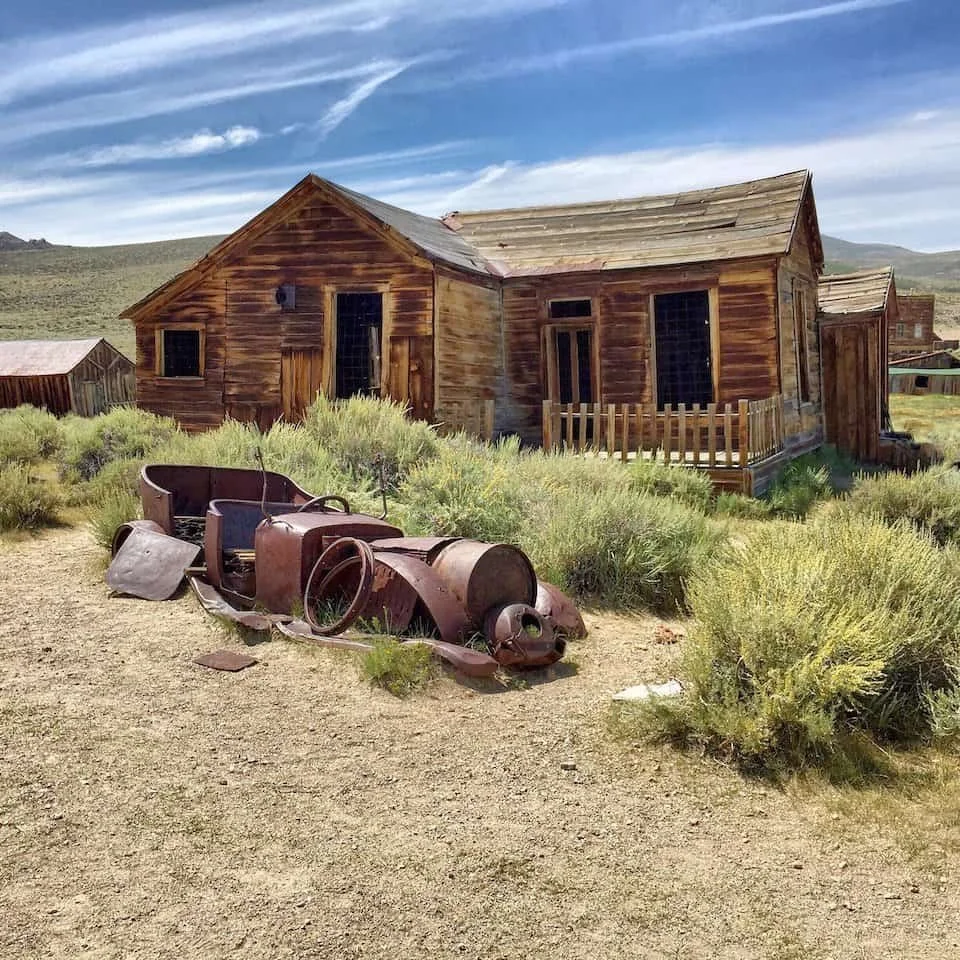 A vintage automobile decaying in the dry grass of the high-desert ghost town of Bodie, California